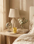 Chrome Orbit Alarm Clock and yellow Crushed mug on a bedside table with a lamp