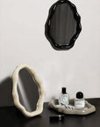 Nordic cloud-shaped vanity mirror set with black and white frames, perfumes, and lipstick on a dark surface.