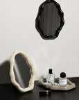 Nordic cloud-shaped vanity mirror set with black and white frames, perfumes, and lipstick on a dark surface.
