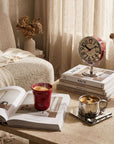 Red Crushed Ceramic Mug and Orbit clock with an open book on a side table