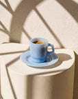 Powder Blue Pastel Muse Mug with espresso on a stone table in sunlight