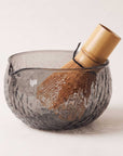 Hand-textured glass matcha bowl with bamboo whisk, smoky finish