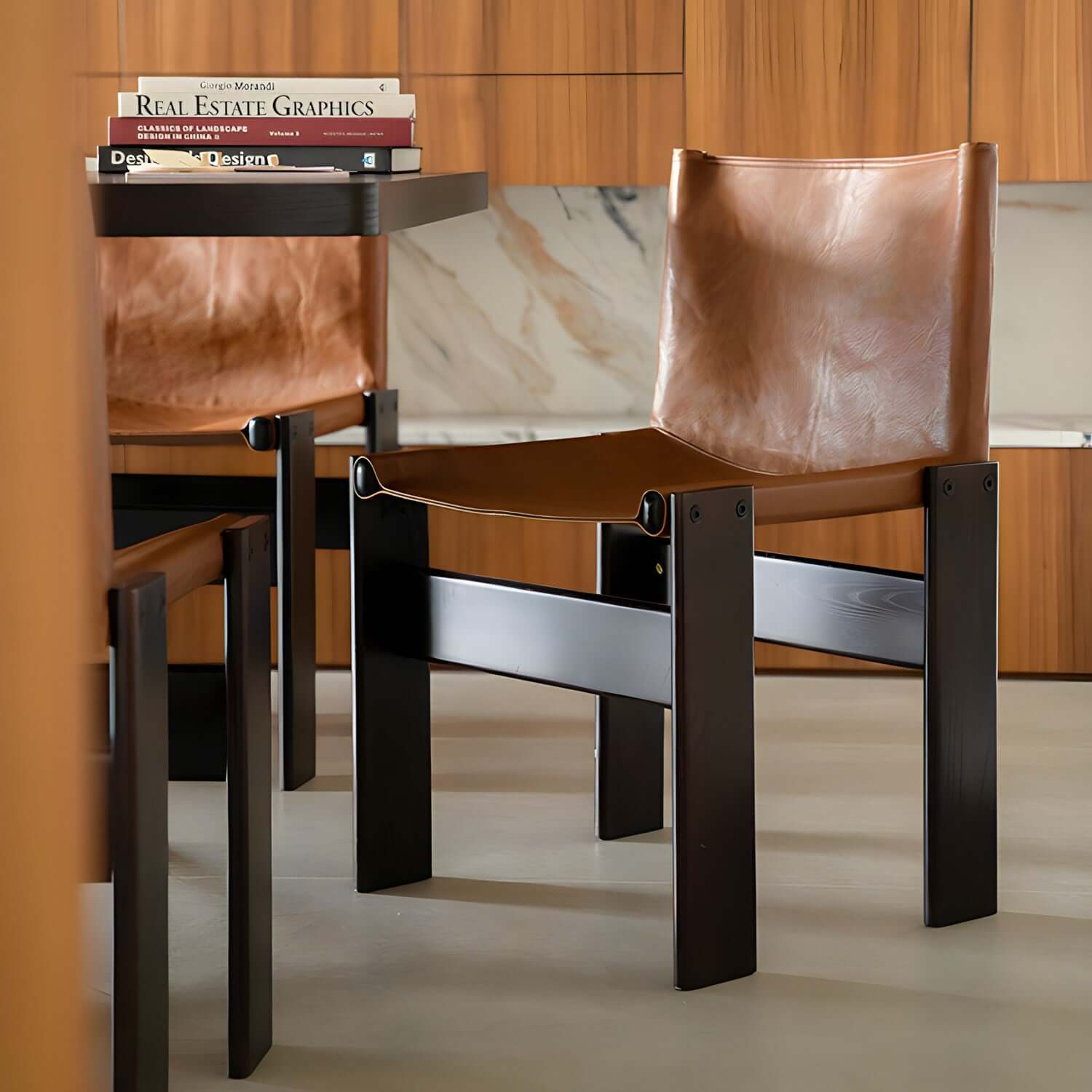 Modern dining chairs with brown leather seats and dark wooden frames in a stylish kitchen setting.