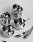Stainless steel spherical cups set with sleek spoons, perfect for elegant dining and serving espresso or desserts.