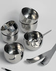 Stainless steel bowls and minimalist dessert spoons set, perfect for modern kitchenware and serving ice cream or coffee.