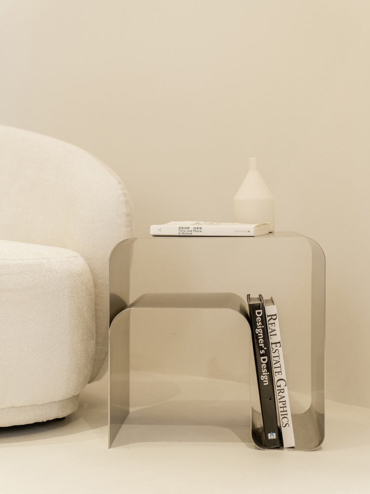 Minimalist stainless steel bedside table with books and decor, contemporary design, ideal for modern home interiors.
