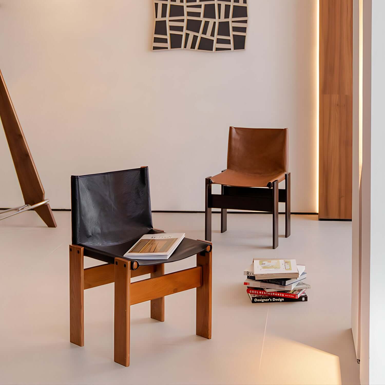Black and brown Nosaku Monk chairs with leather seats and wooden frames in a modern room setting.