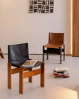 Black and brown Nosaku Monk chairs with leather seats and wooden frames in a modern room setting.