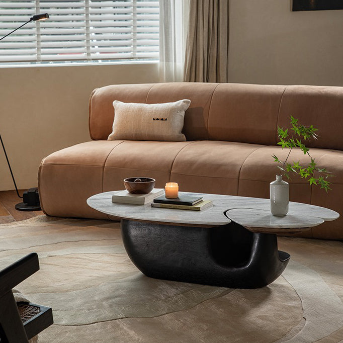 Modern Wabi-Sabi coffee table with wood and stone top, stylishly contrasting in a cozy living room setting.