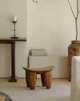 Handcrafted African Senufo wood milk stool in elegant interior, showcasing unique ethnic art and natural wood textures.