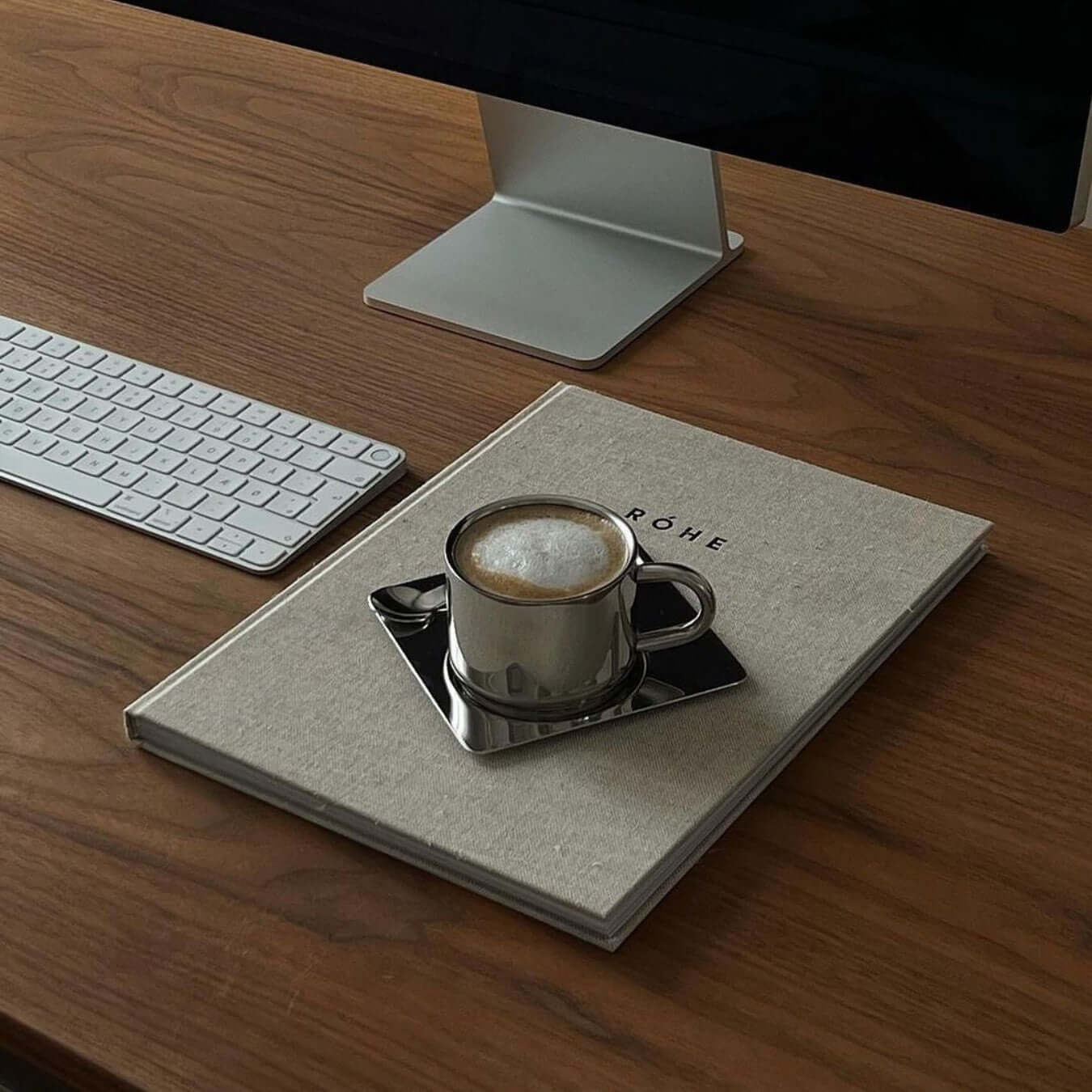 Venice Mirror Cup Set with saucer and spoon on desk, showcasing polished mirror finish and timeless elegance.