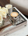 Elegant Venice Mirror Cup Set on books with roses and candle, featuring polished mirror finish for a luxurious coffee experience.