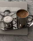 Milano Duo Set with stainless steel cups on marble table, showcasing modern design and functionality for coffee lovers.