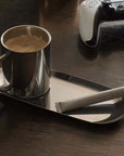 Milano Duo Set with sleek stainless steel coffee cup and tray on a table, ideal for modern settings.