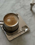 Elegant Venice Mirror Cup Set with polished finish, featuring a coffee cup, saucer, and spoon on a marble surface.