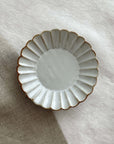 Elegant Marumitsu Barbarie Saucer with fluted design on neutral fabric background. High-quality ceramic tableware.