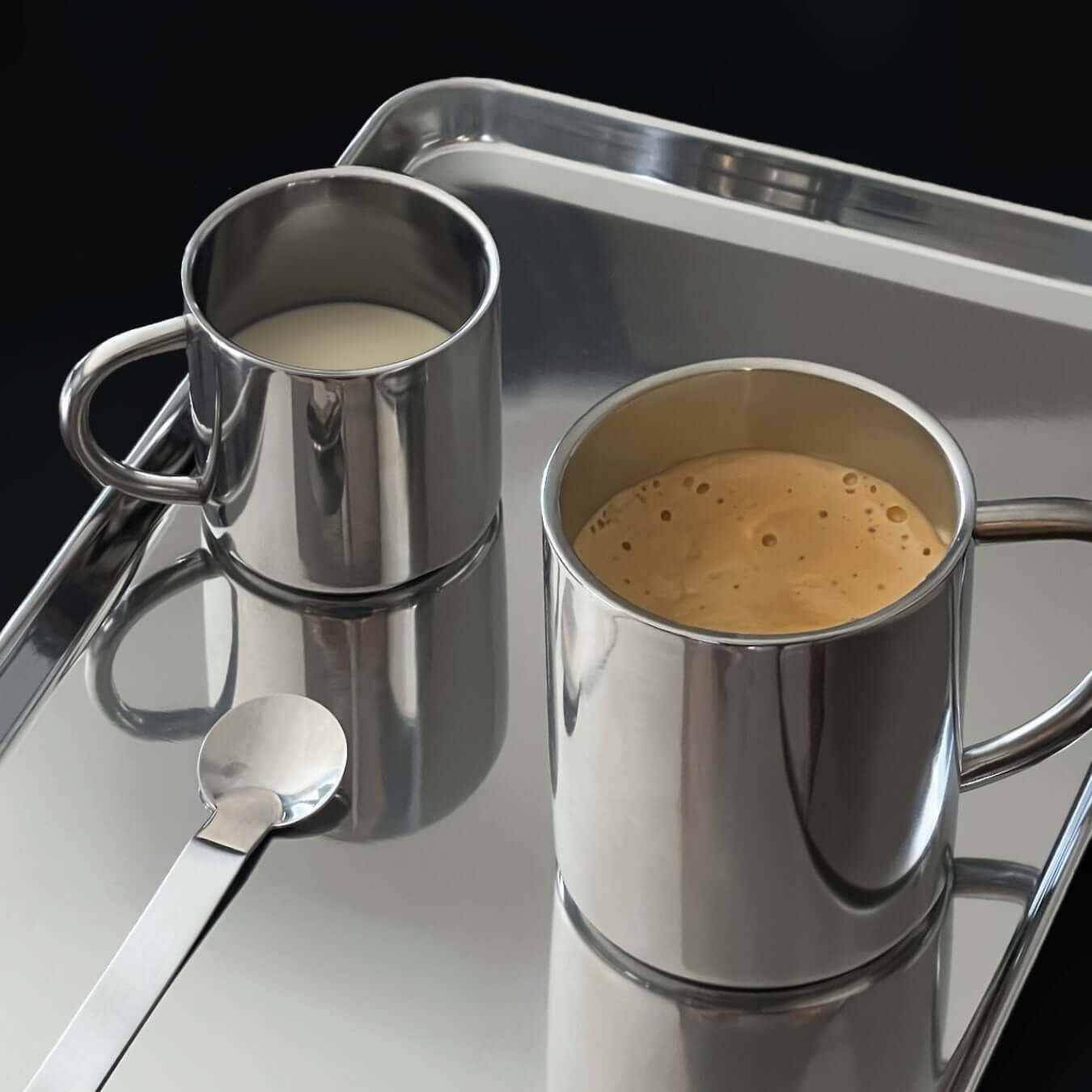 Double-layer glossy stainless steel cups with coffee and milk on a metal tray, showcasing modern elegance and temperature control.