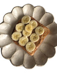 Rinka Plate 21cm with sliced banana on toast, showcasing unique scalloped design and Japanese craftsmanship.