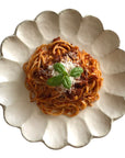 Elegant Rinka Plate 24cm with pasta topping, showcasing Japanese craftsmanship and porcelain design.