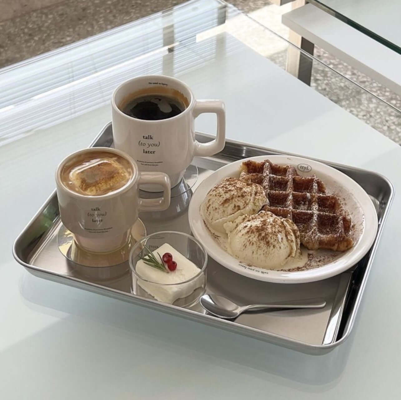 Stainless steel tray with coffee, waffles, and ice cream, showcasing minimalist design and elegance.