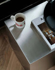 Minimalist Bauhaus Stainless Steel Side Table, top view with a mug and a magazine
