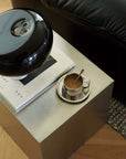 Minimalist Bauhaus Stainless Steel Side Table with a black lamp and an espresso cup