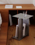 Industrial Minimalist Steel Side Table used as a nightstand with a glass and books