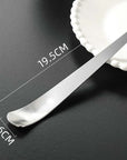Minimalist dessert spoon 19.5cm x 2.6cm on a black surface, next to a white plate. Ideal for ice cream or coffee.