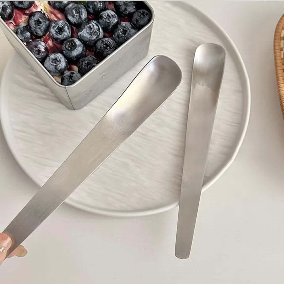 Minimalist dessert spoon set of 2 on a plate with blueberries, ideal for serving modern desserts and coffee, handmade stainless steel.
