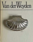 Vintage Shell-Shaped Silver Trinket Case on an art book cover