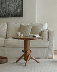 Stylish wooden Clown Table beside a cozy white sofa, adding playfulness and simplicity to the modern living room decor.