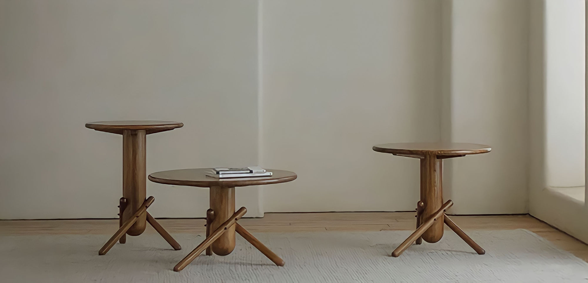 Sleek and playful wooden Clown Tables in three sizes on a minimalist rug, perfect for versatile and imaginative decor.