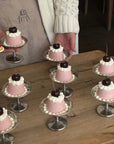 Elegant Dessert Cups filled with pink and white iced cakes served at a party