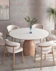 Elegant solid wood round table with white top and six chairs, featuring minimalist Italian design in a stylish dining room setting.
