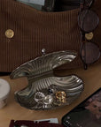 Vintage Shell-Shaped Silver Trinket Case beside a handbag, sunglasses and jewellery