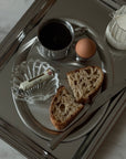 Matte Stainless Steel Oval Plate with a boiled egg, bread and a glass shell dish