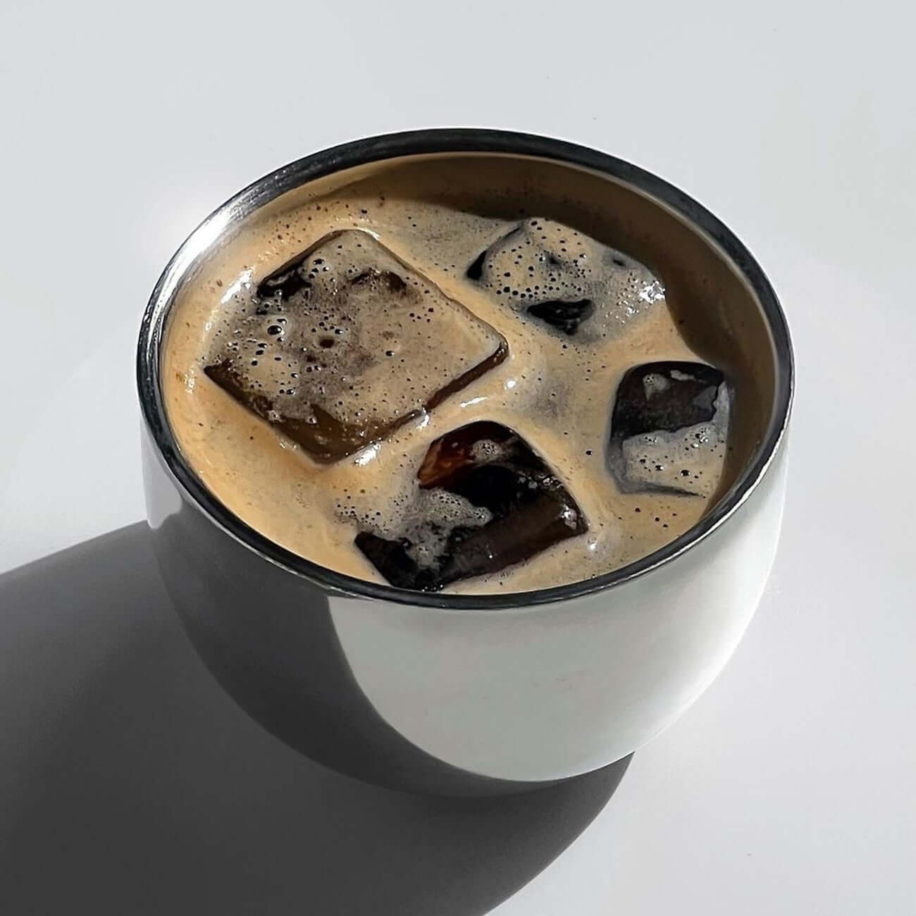 Elegant spherical cup filled with iced coffee, highlighting its modern design and functionality for hot or cold beverages.