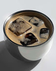 Elegant spherical cup filled with iced coffee, highlighting its modern design and functionality for hot or cold beverages.