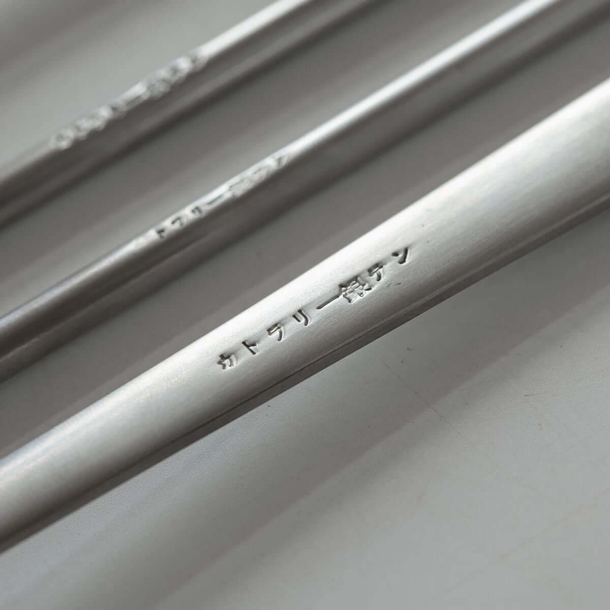 Japanese retro stainless steel cutlery set close-up with engraved text.