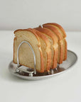 Stainless steel toast holder with six slices of bread, featuring a mirror finish for an elegant breakfast presentation.