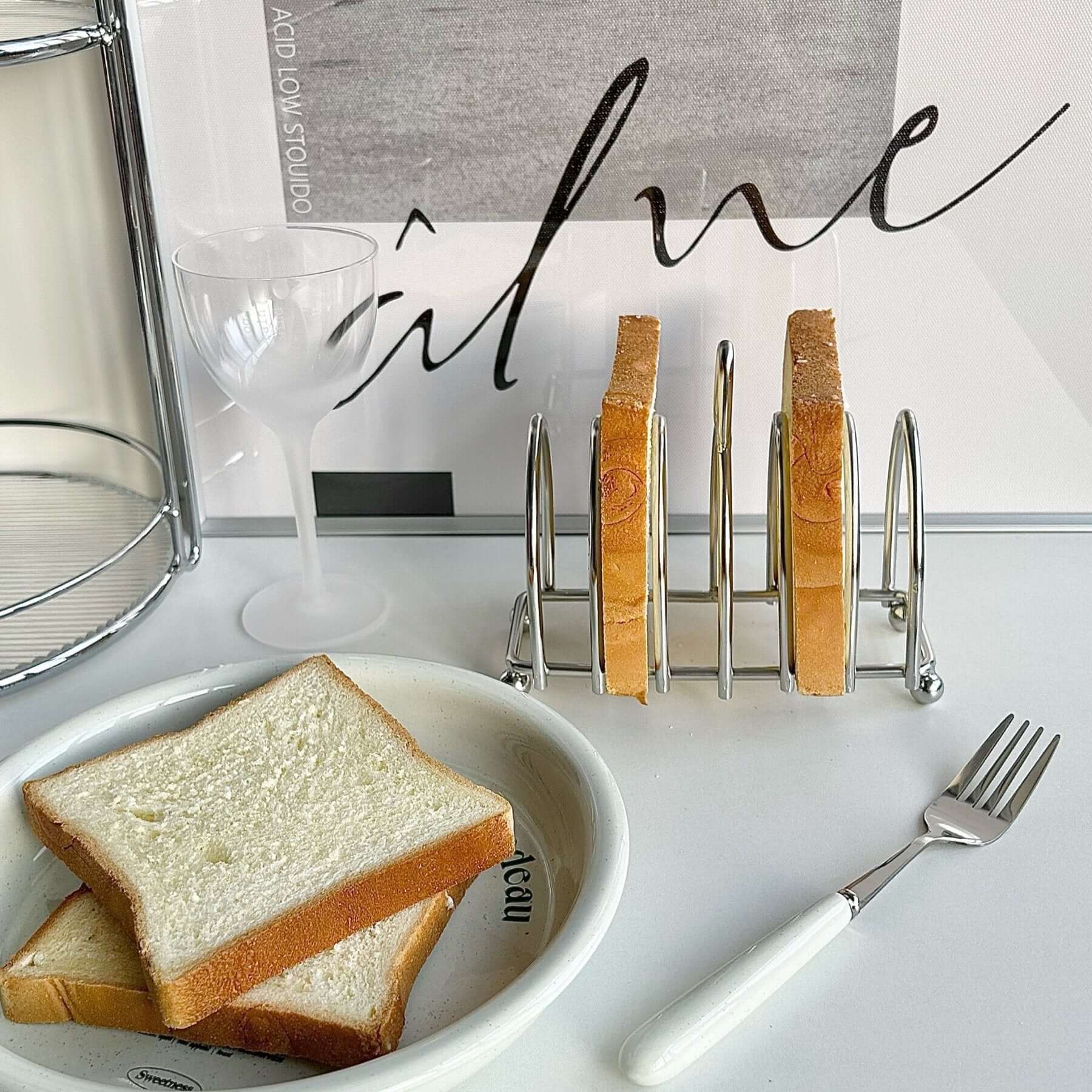 Stainless steel toast holder with slices, elevating breakfast table aesthetics. Sophisticated design and functionality.