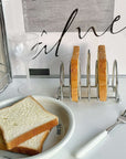 Stainless steel toast holder with slices, elevating breakfast table aesthetics. Sophisticated design and functionality.