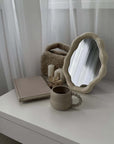 Nordic cloud-shaped vanity mirror on a table with book, cup, and candles, enhancing home decor with modern elegance and free shipping.