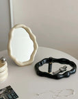 Nordic cloud-shaped vanity mirror in cream and black with accessories, on a white table, size 27x20cm - 10.6x7.85 inches, free shipping.