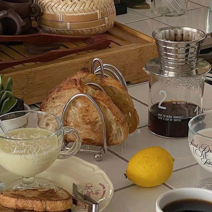 Elegant stainless steel toast holder with fresh bread, perfect for a sophisticated breakfast setup.