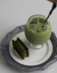 Lumi Stem Glass with iced matcha latte on a scalloped plate with a matcha cake