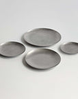 Hakone Plates in four sizes laid out, matte stainless steel