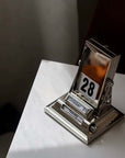 Nordic Rotating Desk Calendar with metallic finish showing October 28, minimalist design, tabletop date keeper, 7x8x10.5cm.