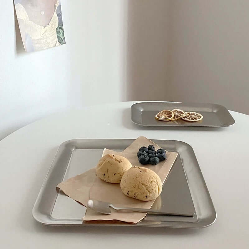 Urban Chic stainless steel serving tray with scones, blueberries, and a knife on a table. Minimalist design for elegant dining.