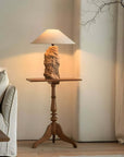 Custom-crafted wooden lamp on a wooden side table, illuminating a cozy living room corner.